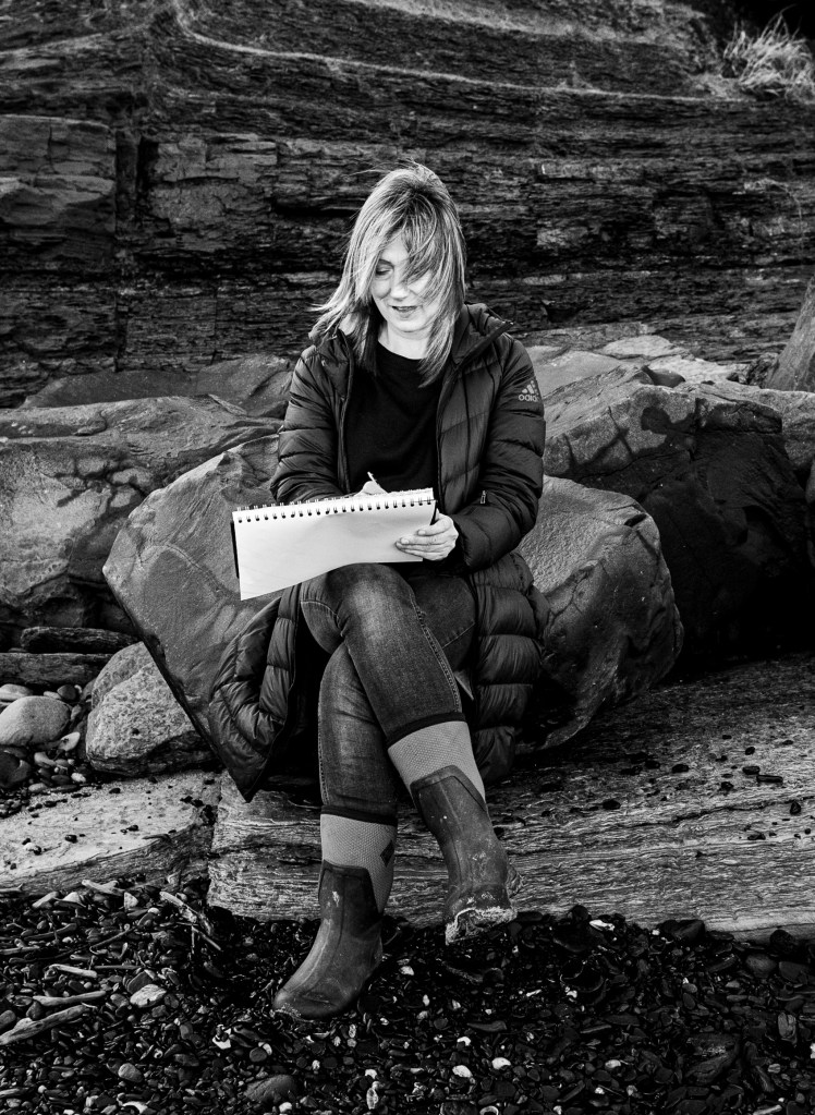 Katherine Renton sketching on a beach