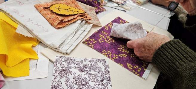Closup picture of fabric remnants and people crafting
